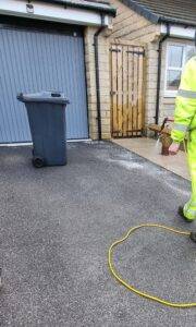 Biocide treatment applied after pressure washing to prevent algae and moss regrowth on driveway surface