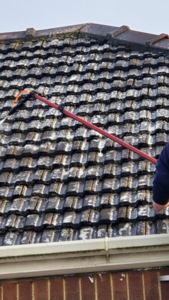 Biocide treatment being applied to roof tiles in Leeds during roof cleaning to help reduce moss and algae regrowth