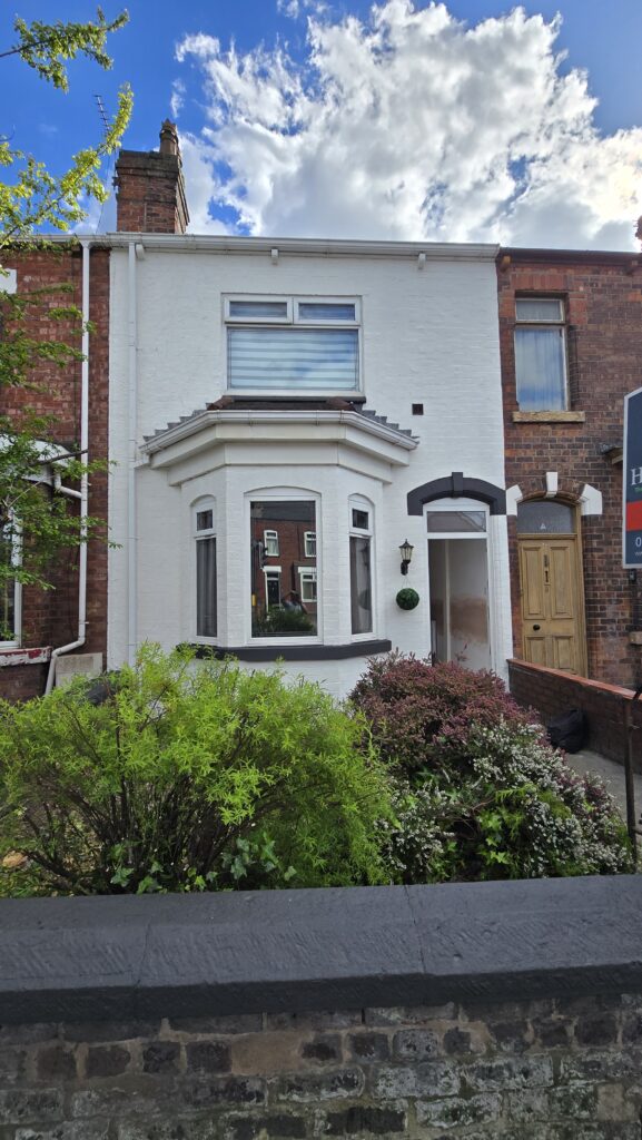 Final view of a house exterior after ivy removal, gutter cleaning, wall tidying and fresh white exterior painting in Greater Manchester.