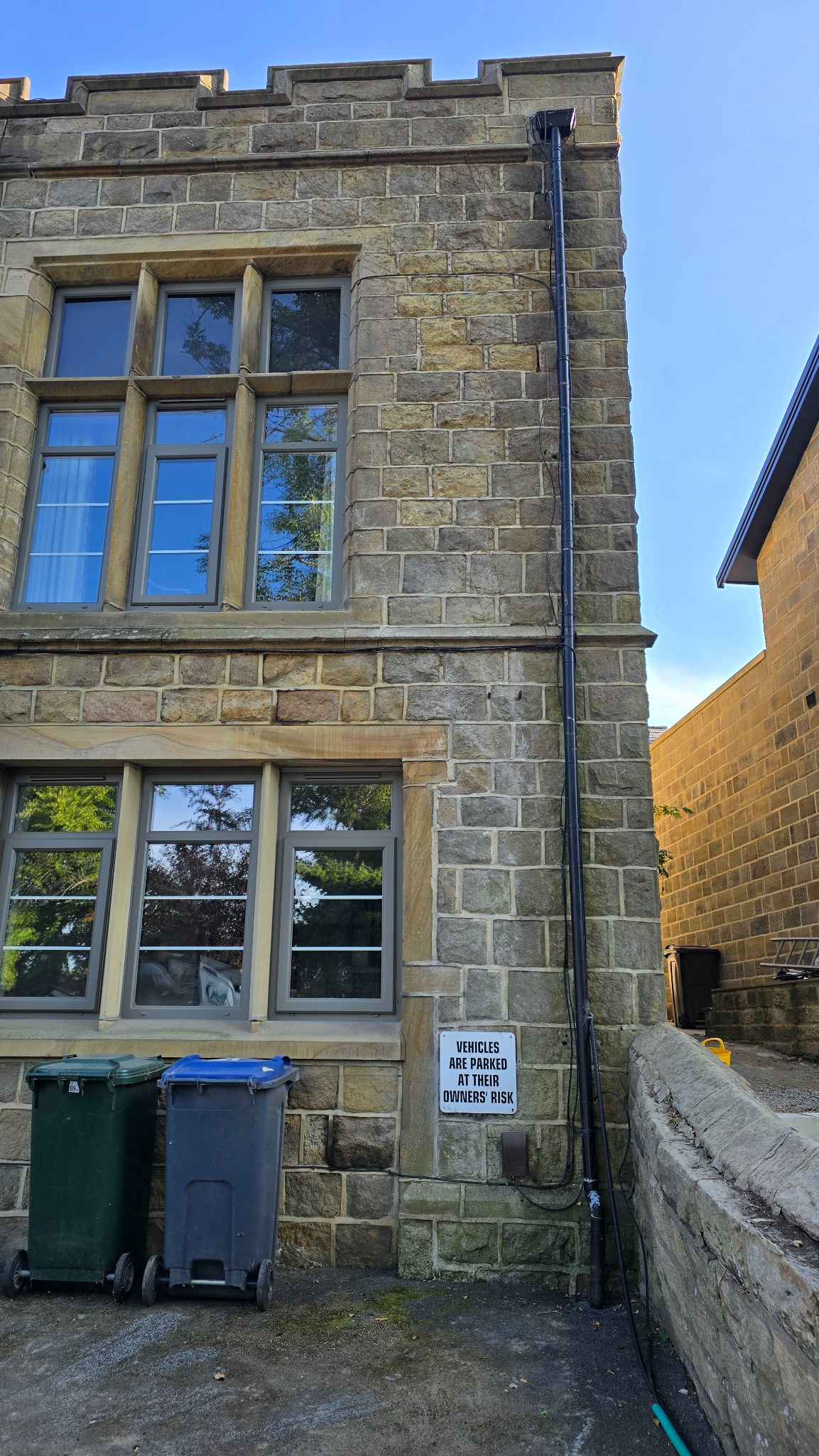 Stone elevation in Ilkley after established ivy was removed from around the windows and downpipe